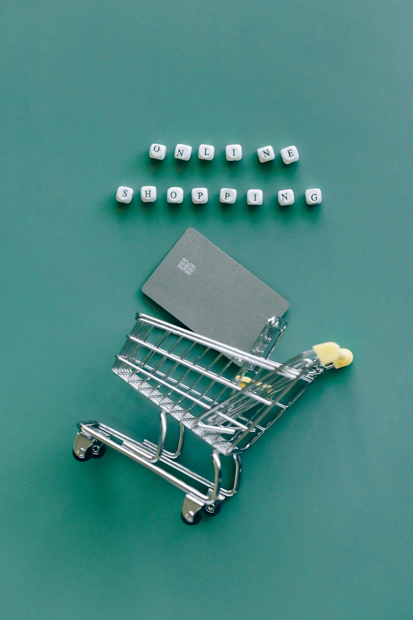 A miniature shopping cart with a credit card illustrates online shopping trends.